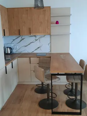 a small kitchen with a wooden table and chairs at Eagles Locus Apartments in Ulcinj