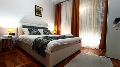 a bedroom with a bed and a large window at Apartment Centar in Podgorica