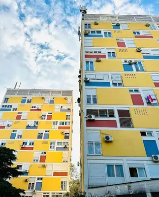 a tall apartment building with colorful windows on it at Apartment Centar in Podgorica