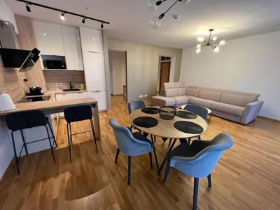 a kitchen and a living room with a table and chairs at Budva Harmonia in Boreti