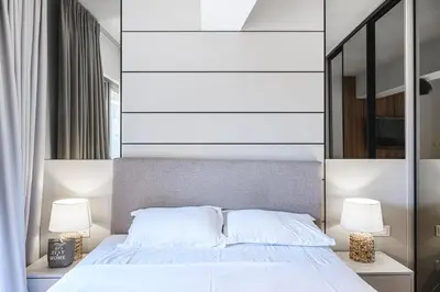 a bedroom with a white bed with two lamps at Budva Harmonia in Boreti