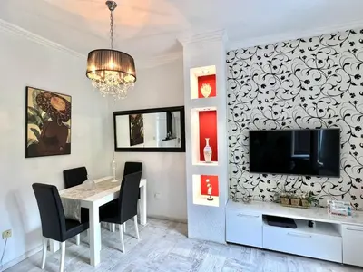 a dining room with a table and a tv on a wall at Apartment Kiki in Kotor