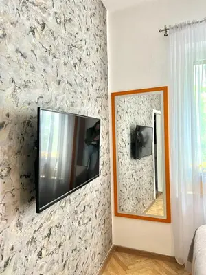 a flat screen tv on a wall next to a mirror at Apartment Kiki in Kotor