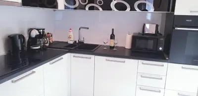 a kitchen with white cabinets and a microwave and a sink at Apartment Kiki in Kotor