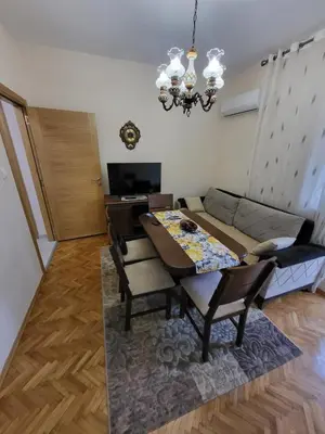 a living room with a table and a couch at Centre Podgorica apartment in Podgorica
