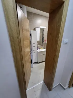a bathroom with a door open to a bathroom with a sink at Centre Podgorica apartment in Podgorica