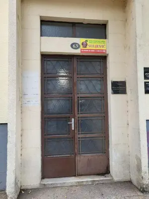 a door to a building with a sign above it at Centre Podgorica apartment in Podgorica