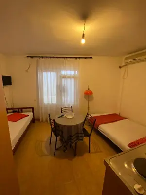 a room with two beds and a table and chairs at Apartmani Jovanovic Canj in Čanj