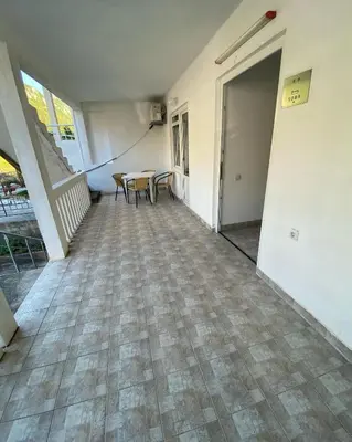 an empty hallway with a table and chairs in a house at Apartmani Jovanovic Canj in Čanj