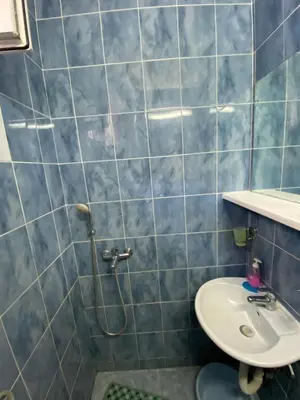 a blue tiled bathroom with a sink and a shower at Apartmani Jovanovic Canj in Čanj