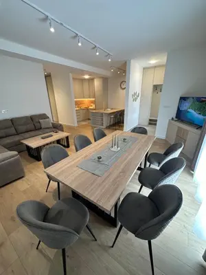 a living room with a wooden table and chairs at Fratelli Apartments in Tuzi