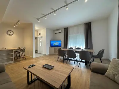 a living room with a table and a dining room at Fratelli Apartments in Tuzi