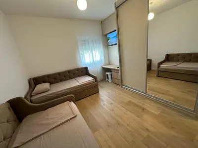 a living room with a couch and a mirror at Fratelli Apartments in Tuzi