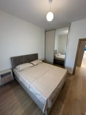 a bedroom with a bed and a large mirror at Fratelli Apartments in Tuzi