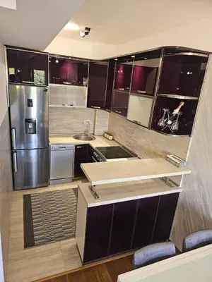 a kitchen with stainless steel appliances and wooden cabinets at AS Apartment in Podgorica
