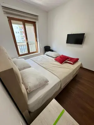 a bedroom with two beds and a flat screen tv at Sunshine Master apartment in Podgorica