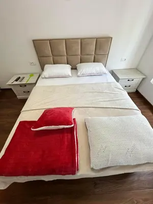a bedroom with a large bed with a red blanket at Sunshine Master apartment in Podgorica