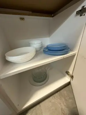 a shelf with plates and bowls in a cabinet at Sunshine Master apartment in Podgorica