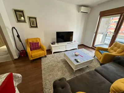 a living room with a couch and a tv at Sunshine Master apartment in Podgorica