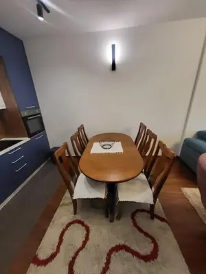 a dining room with a wooden table and chairs at Master apartment Podgorica in Podgorica