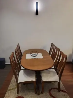 a wooden table with four chairs and a candle at Master apartment Podgorica in Podgorica