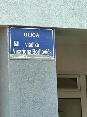 a blue street sign on the side of a building at Master apartment Podgorica in Podgorica