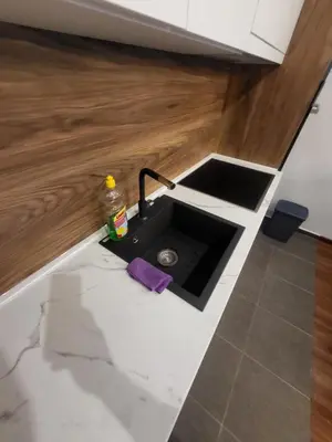 a kitchen counter with a sink in the middle of it at Master apartment Podgorica in Podgorica