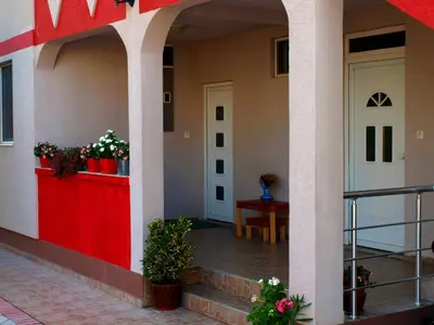 a front porch of a house with potted plants at Friendly House in Ulcinj