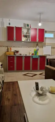 a kitchen with red cabinets and a bowl on a table at Milan Apartman in Podgorica