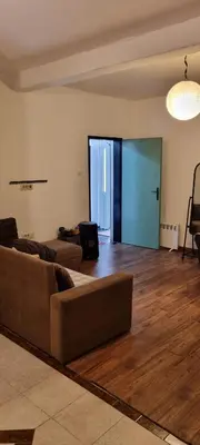a living room with a couch and a wooden floor at Milan Apartman in Podgorica
