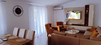 a living room with a couch and a table and chairs at Apartman Lara 3 in Trojica