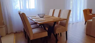 a dining room table with chairs and a wooden tableablish at Apartman Lara 3 in Trojica