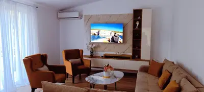 a living room with a couch and chairs and a tv at Apartman Lara 3 in Trojica