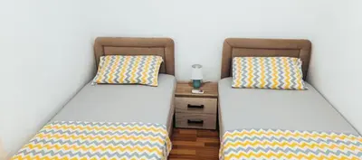 two beds sitting next to each other in a room at Apartman Lara 3 in Trojica