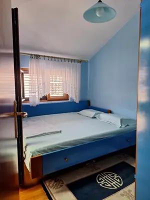 a blue bedroom with a bed with a window at Adriatic Luxury Flat in Budva