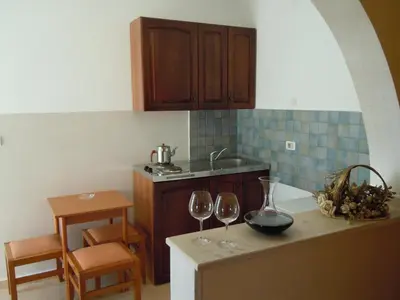 a kitchen with two wine glasses on a counter at Vila Maslina Guesthouse in Budva