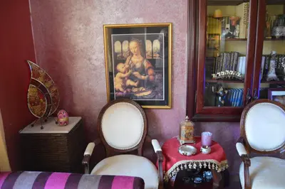 a room with two chairs and a table and a painting at Vila Maslina Guesthouse in Budva
