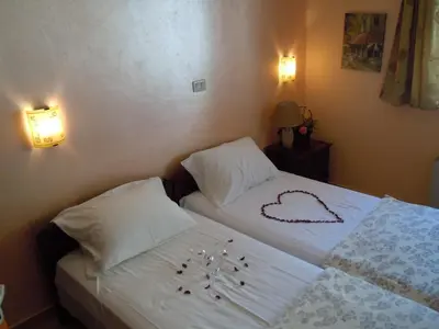 a bedroom with two beds with white sheets and pillows at Vila Maslina Guesthouse in Budva
