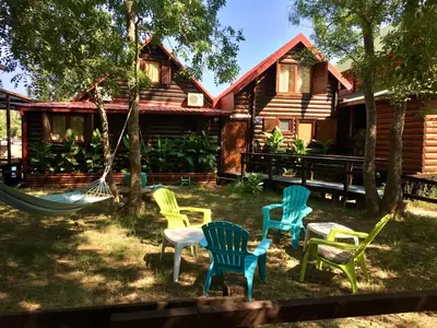 a group of chairs in front of a log cabin at Amazing &Magic houses- Ada Bojana in Gornji Štoj