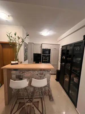 a kitchen with a counter with two stools at it at Sea view in Rafailovici