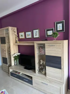a wooden entertainment center with a television in a living room at Sea view in Rafailovici