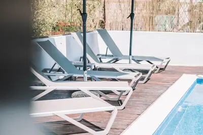 a row of lounge chairs next to a swimming pool at Bivalvia Apartments in Ulcinj