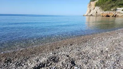 a rocky beach with blue water and a rocky shore at Apartment Dasic in Bar