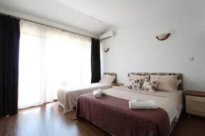 a bedroom with two beds and a large window at Apartment Dasic in Bar