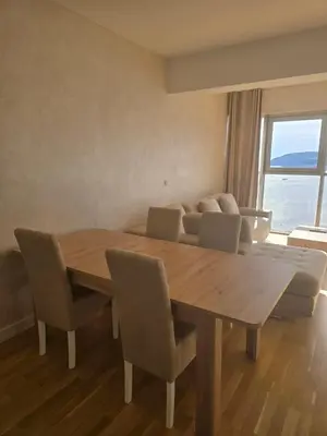 a dining room with a table and chairs and a couch at Harmonia Budva 1 in Budva