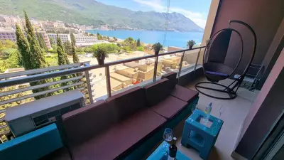 a balcony with a couch and a view of the ocean at Harmonia Budva 1 in Budva