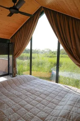 a bedroom with a large bed with a large window at Amazonas Pirates 4 in Gornji Štoj