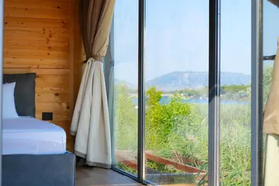 a bedroom with a bed and a large glass window at Amazonas Pirates 4 in Gornji Štoj