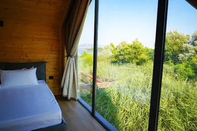 a bedroom with a bed and a large window at Amazonas Pirates 4 in Gornji Štoj