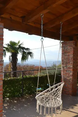 a white swing hanging from a porch with a palm tree at Peuta Hill in Stara Zlatica